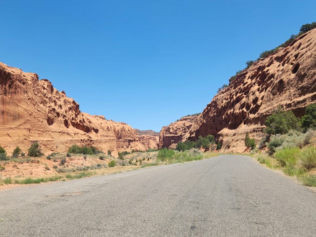 A road in the middle of a desert with a mountain in the background