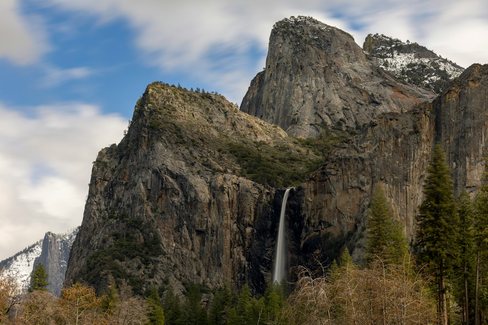 A tall mountain with a waterfall in the middle of it