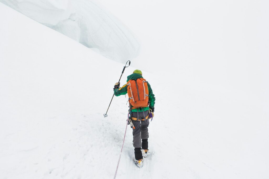 Person walking on snow covered mountain.