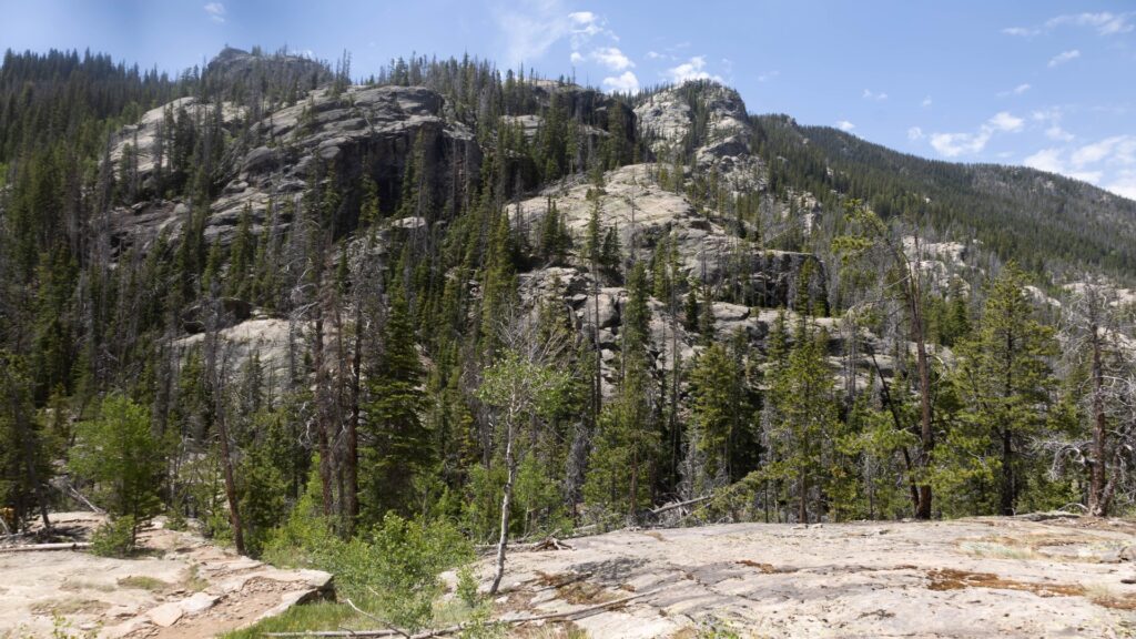 Majestic rocky mountain peak under a clear blue sky, showcasing the natural beauty of Rocky Mountain National Park.