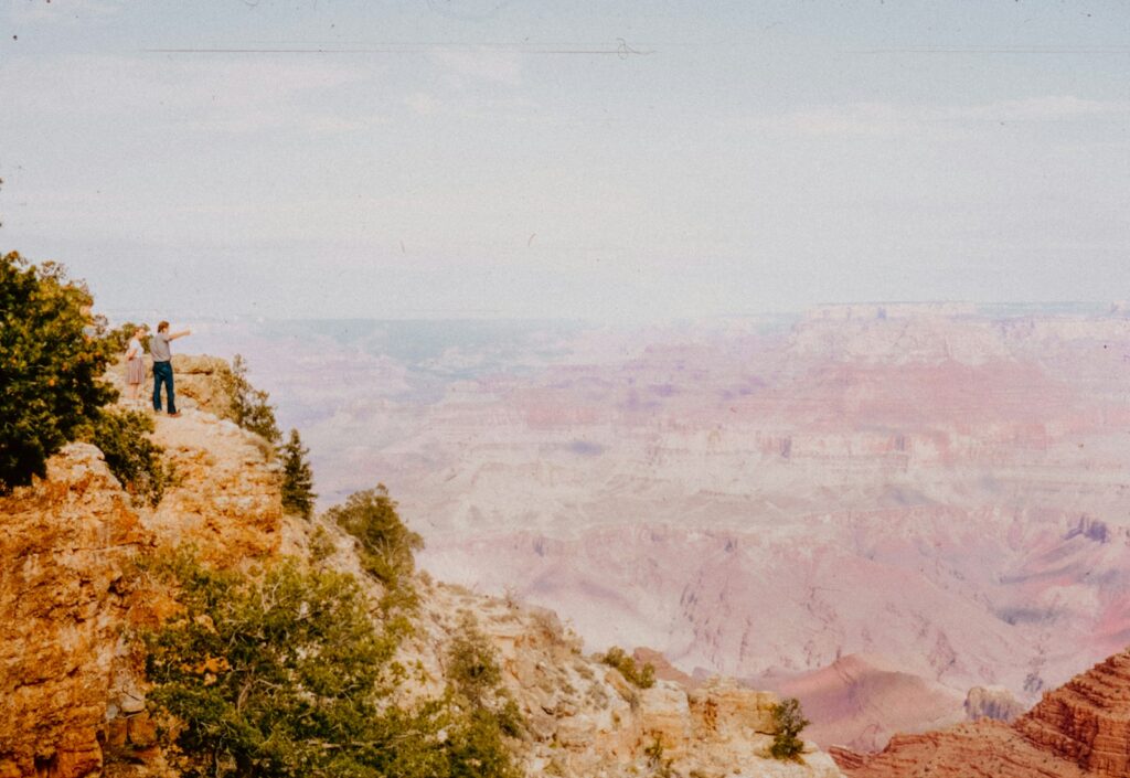 A man standing on a cliff overlooking the grand canyon