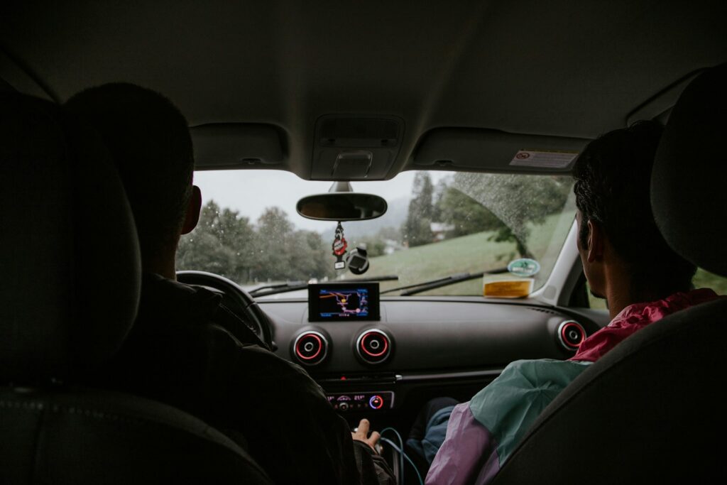 Two men sitting on car front seats