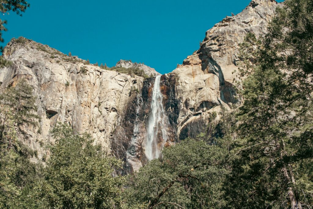 A waterfall is seen from the bottom of a cliff