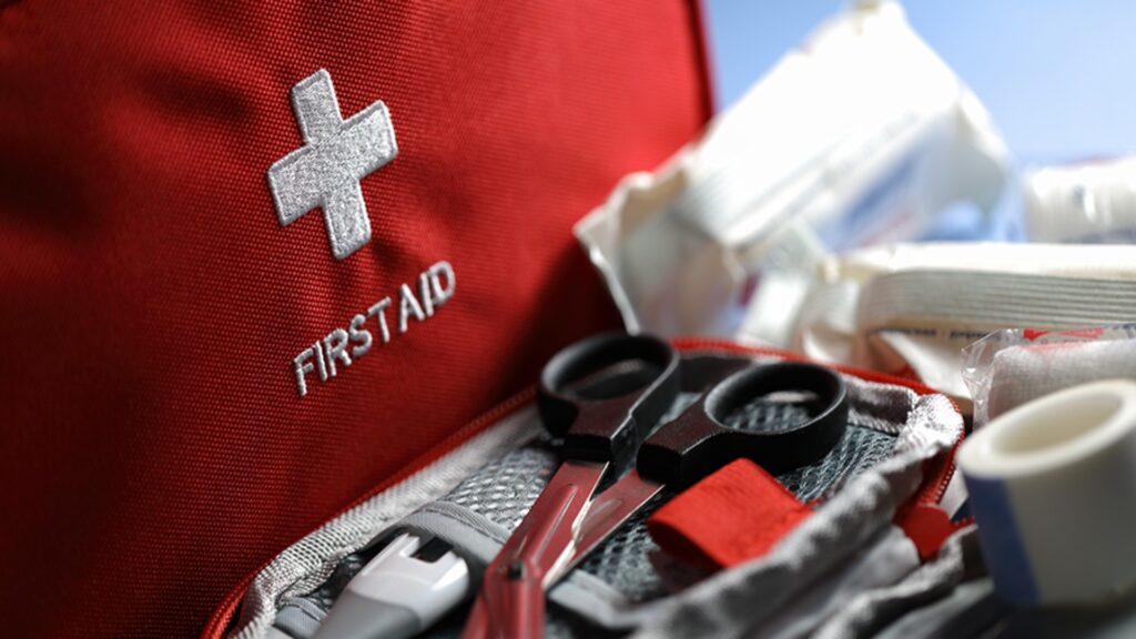 First aid kit containing scissors, bandages, and various medical supplies for emergency care.