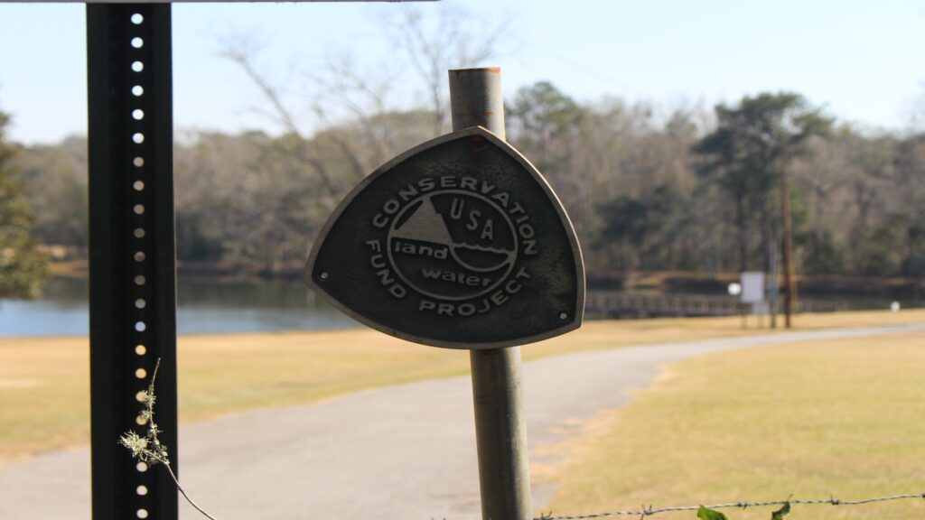 A sign on a pole promoting The Land and Water Conservation Fund, highlighting its role in protecting natural resources.