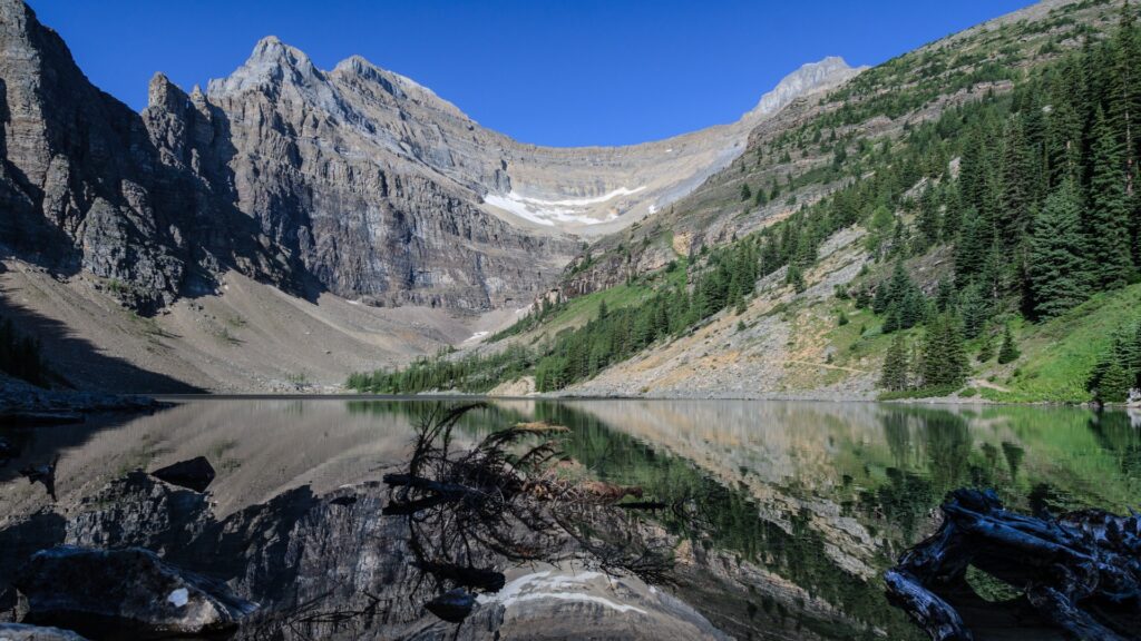 A breathtaking mountain range reflects perfectly in a still lake, showcasing the beauty of the natural landscape.
