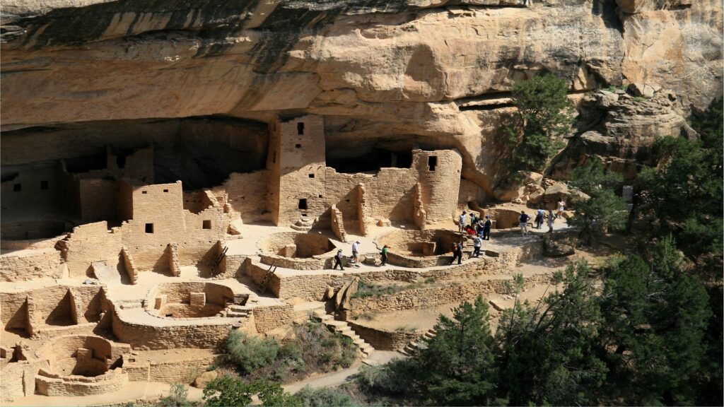 A prominent rock cliff with a structure built into it, highlighting the unique geological and cultural heritage of Mesa Verde National Park.