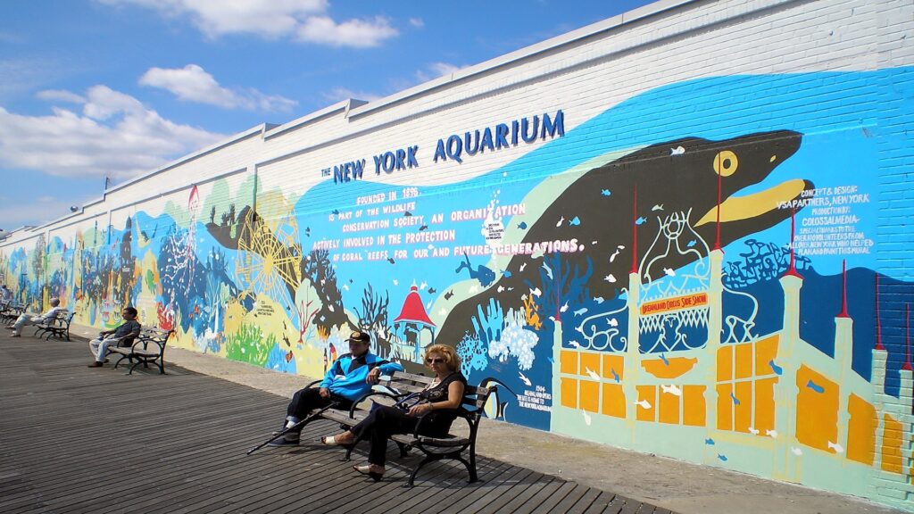 Colorful mural depicting marine life on a building of New York Aquarium, showcasing vibrant ocean scenes.