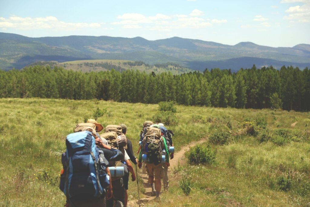 A team of adventurers hikes through rugged mountain terrain, enjoying the breathtaking views and fresh air.
