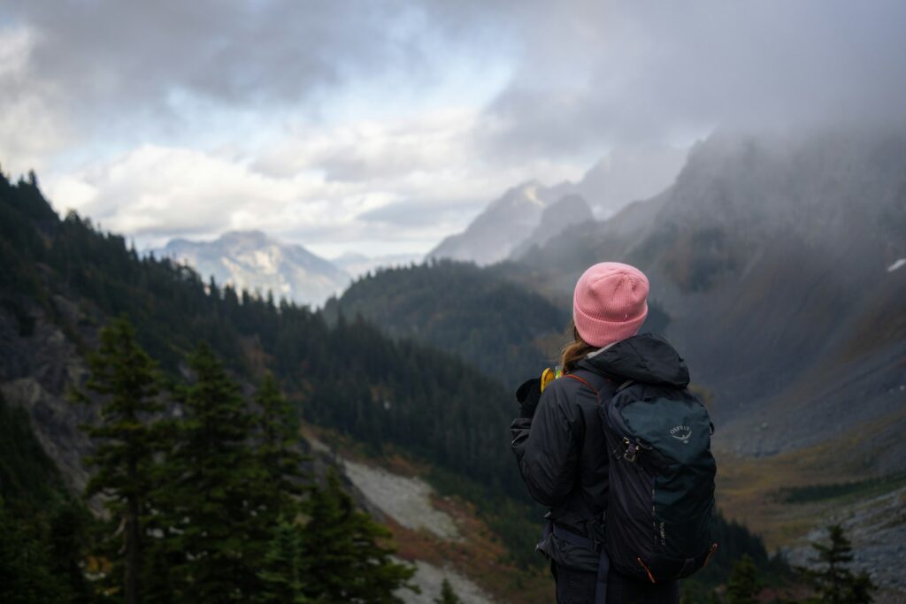 A person with a pink hat standing on a mountain