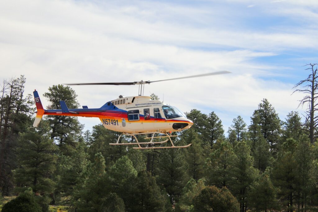 A helicopter that is flying over some trees