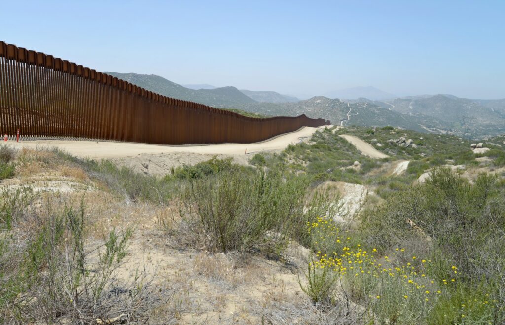 A large metal fence in the middle of a desert