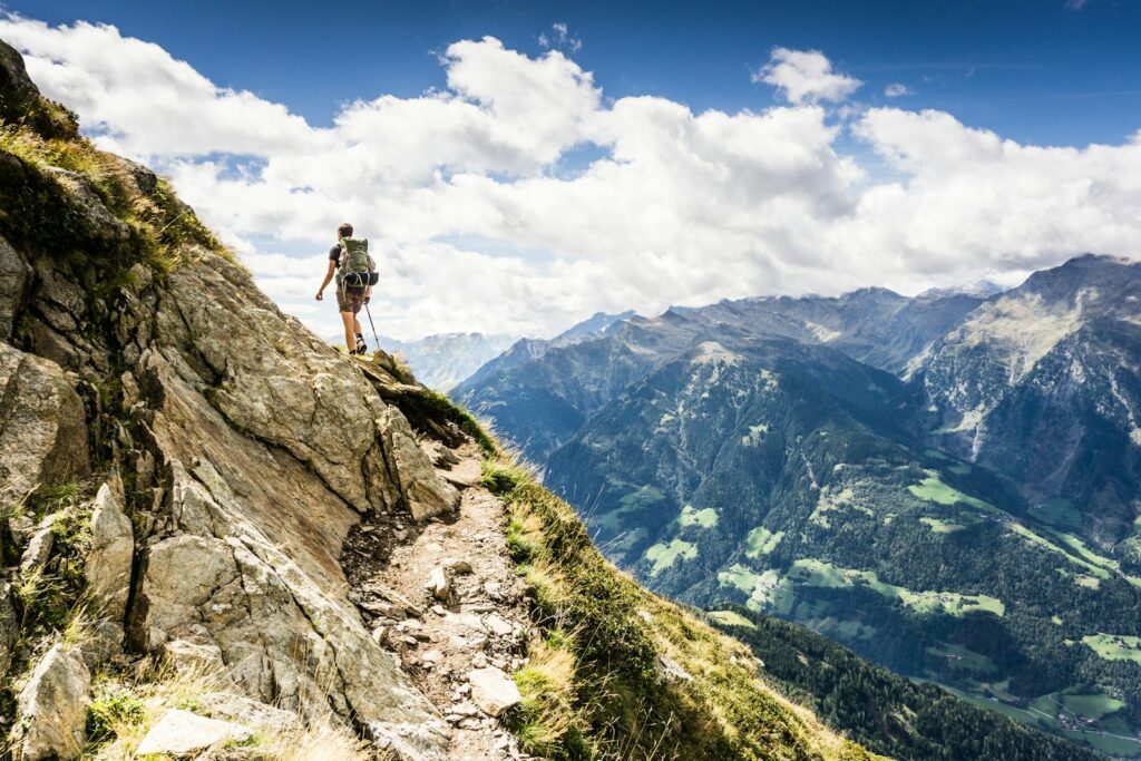 Person standing on top of mountain during daytime