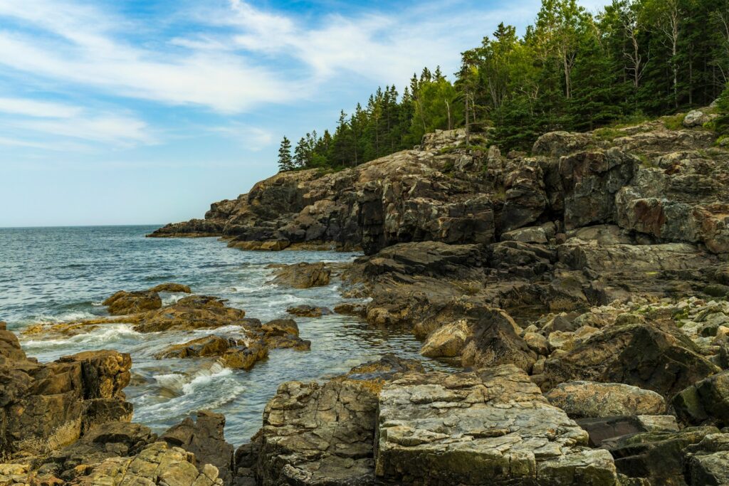 brown rocky mountain beside body of water during daytime