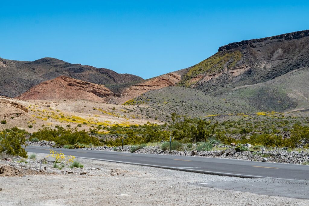 a road in the middle of a desert with mountains in the background