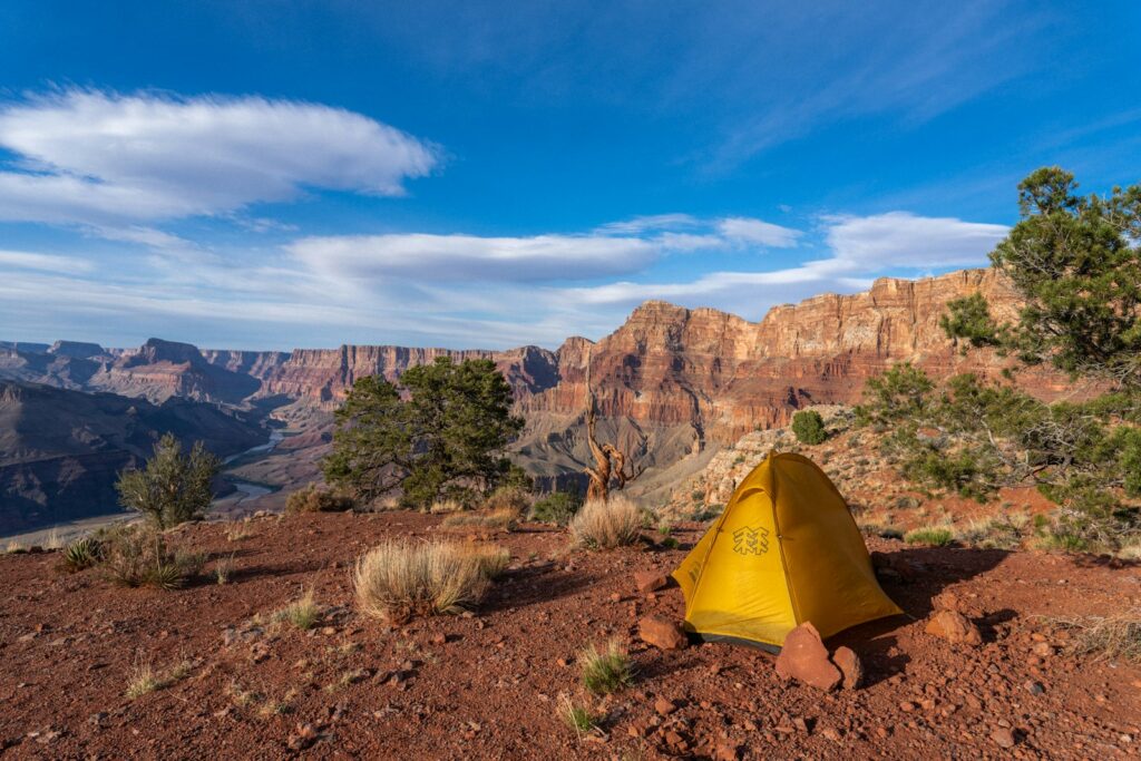 A yellow tent sitting on top of a mountain