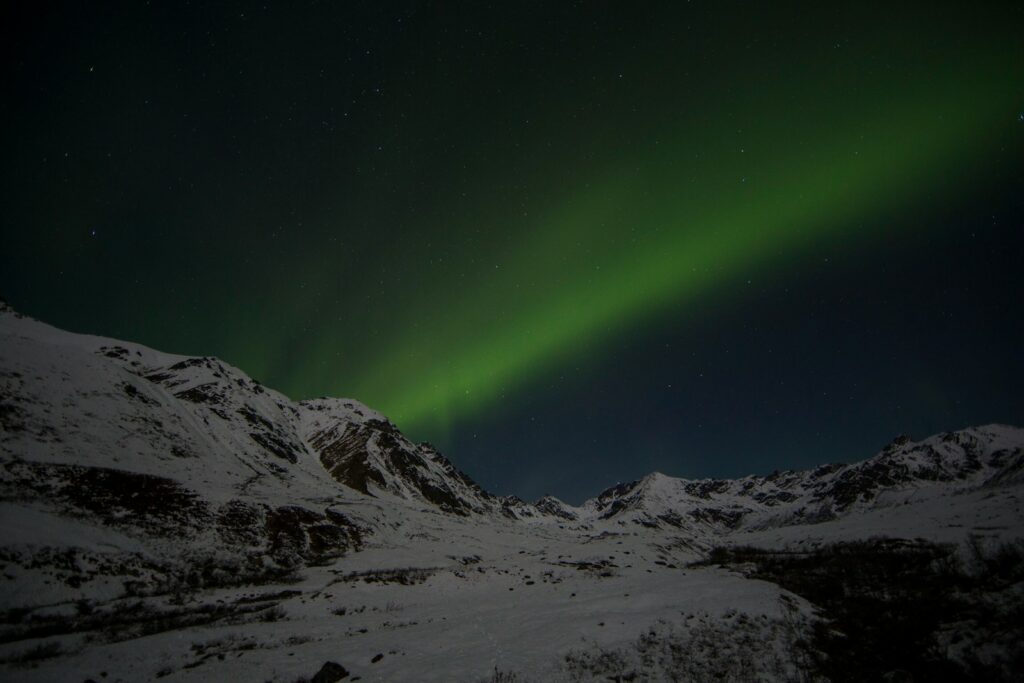 snow capped mountain under aurora lights