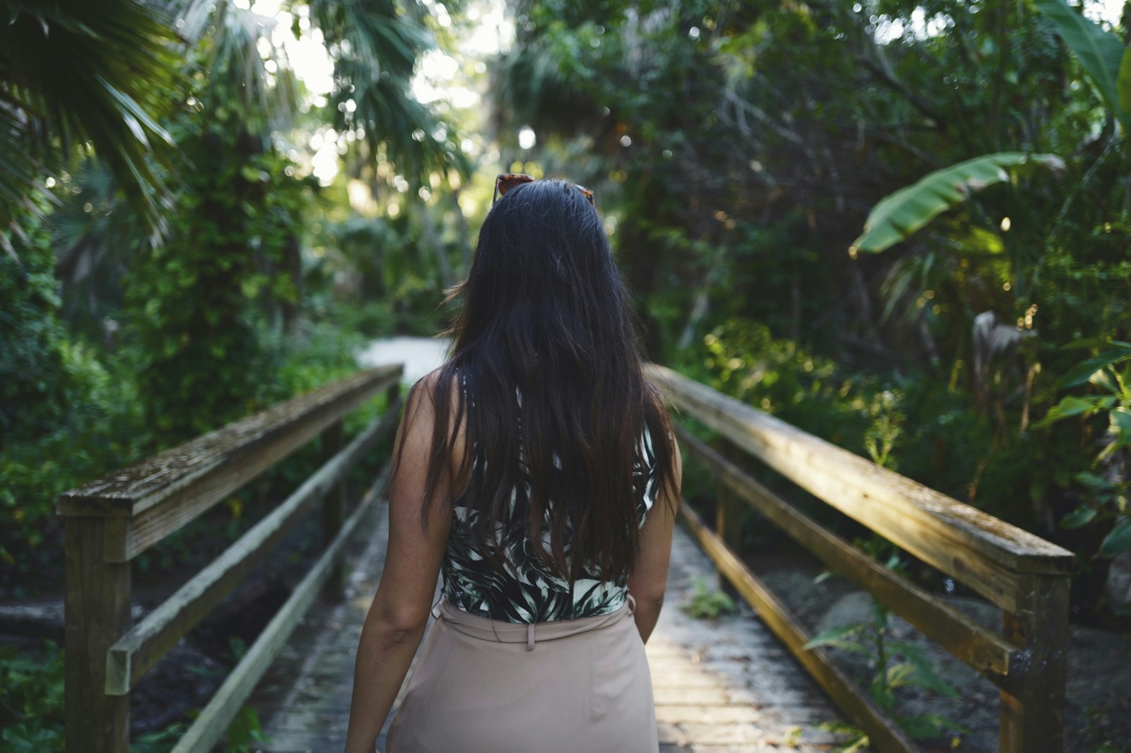 Woman wearing black sleeveless top walking on dock