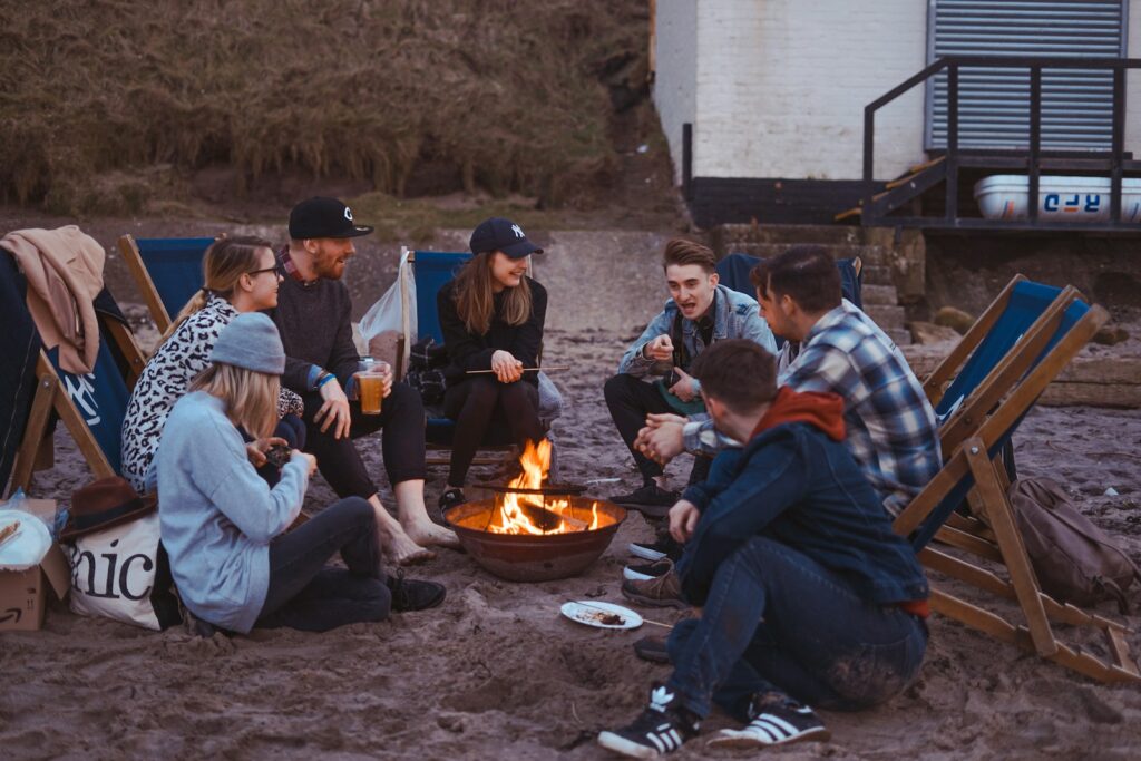 Group of people sitting on front firepit.