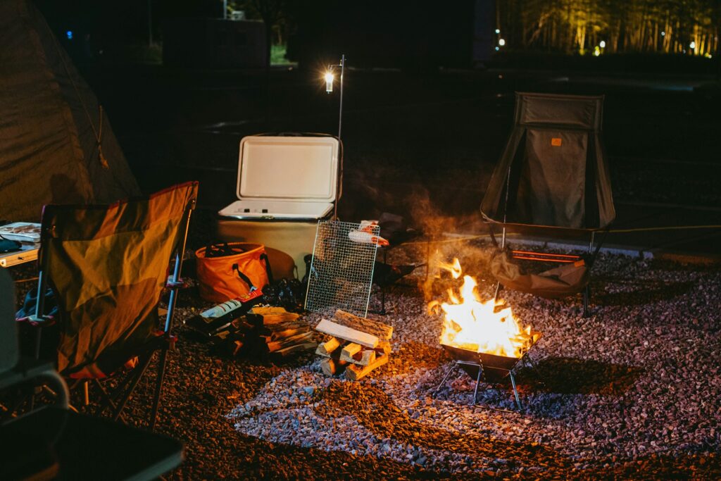 Cozy campsite with a glowing fire pit surrounded by chairs, perfect for storytelling under the stars.