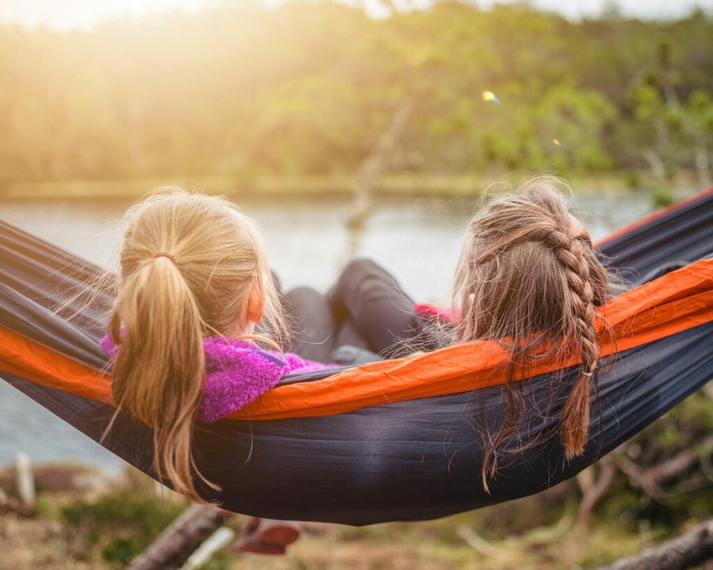 Two kids lying on hammock.