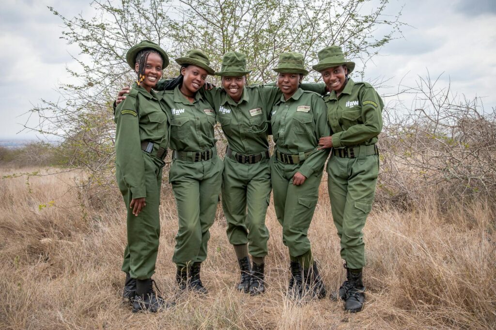 Smiling team of female wildlife rangers in Kenya, promoting conservation efforts.