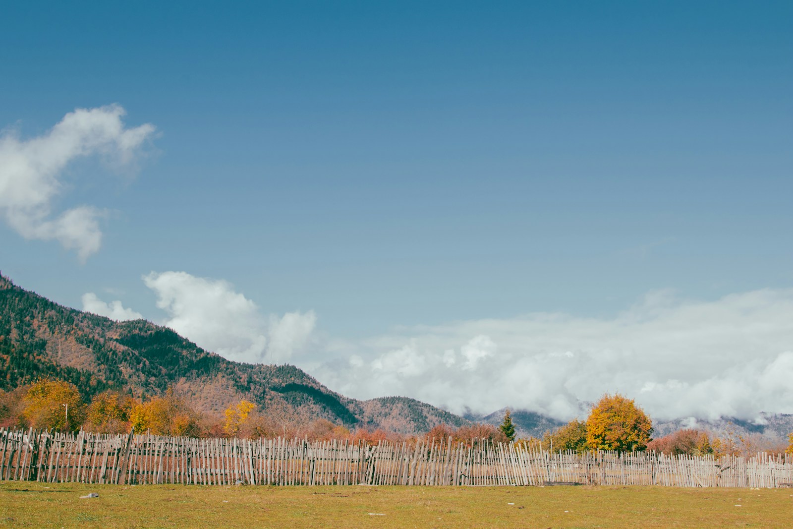 Mountains and fence under a blue sky.