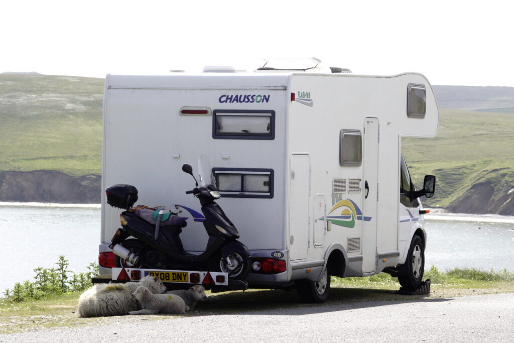 Sheep in the shade of a campervan at the Hermaness car park