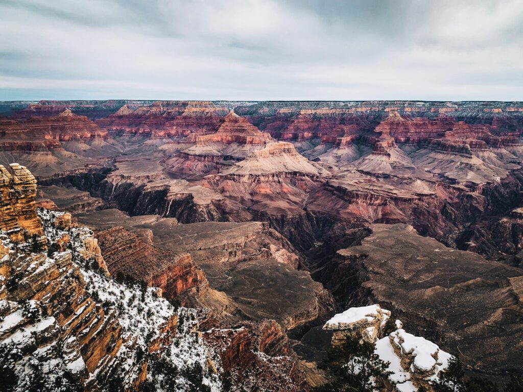 brown and white rocky mountain under gray sky