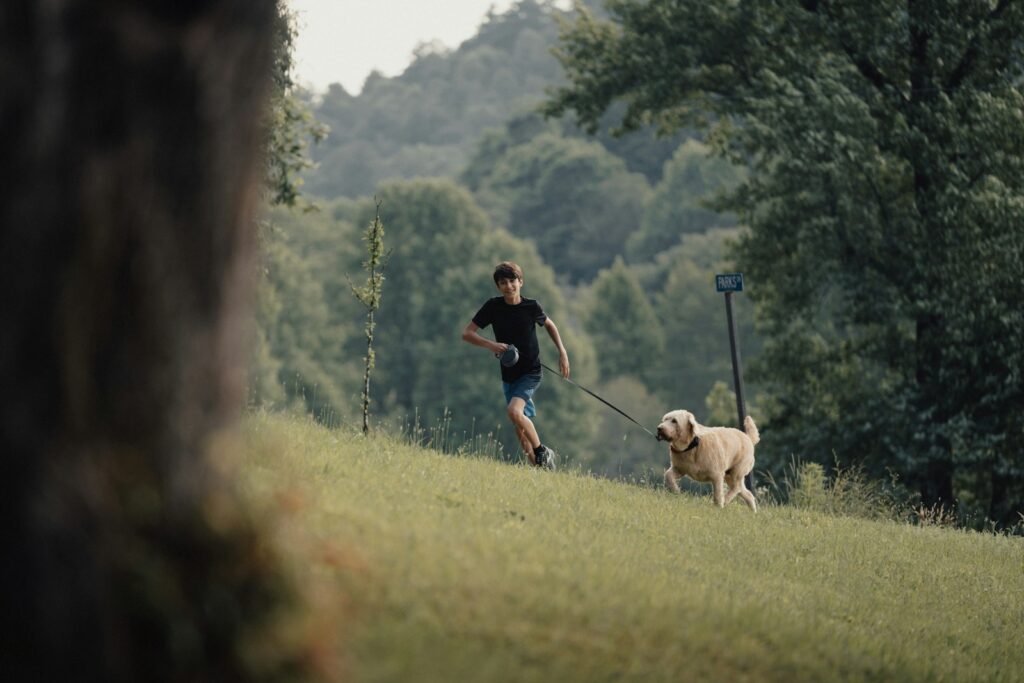 A man running with a dog on a leash.