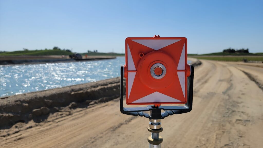 A red and white sign sitting on the side of a road.