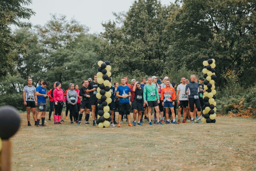 People in green and black shirts standing on brown field during daytime.