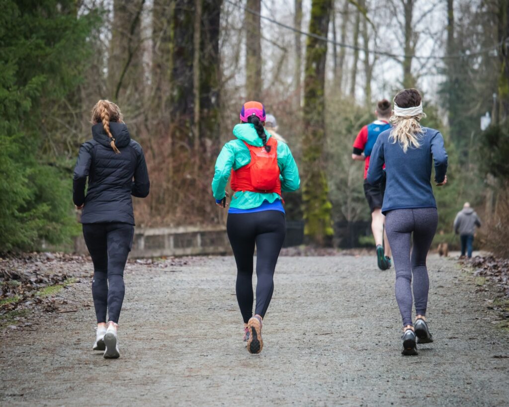 A group of people running down a dirt road.