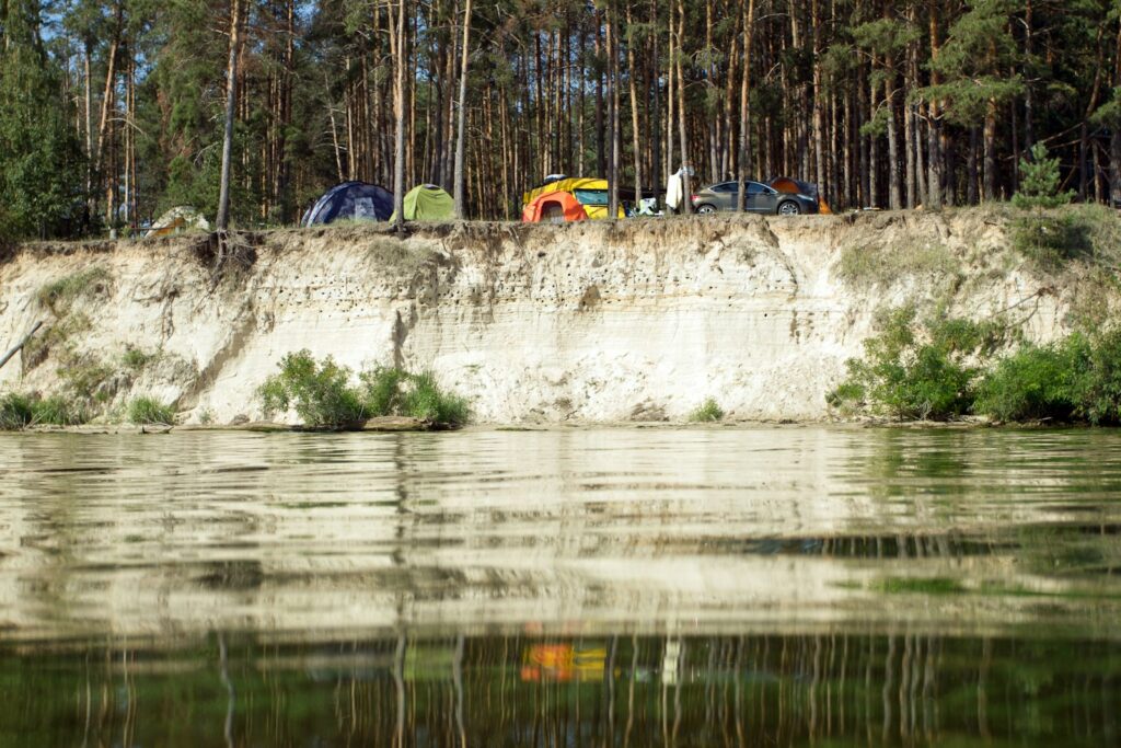 A group of tents sitting on top of a cliff next to a body of water.