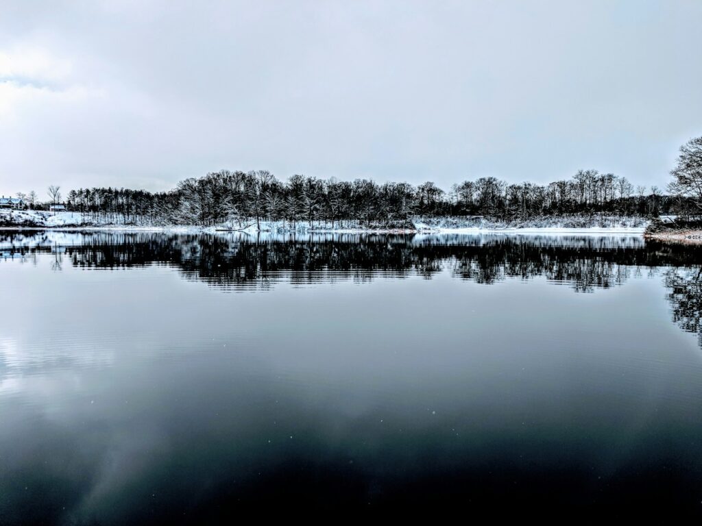 body of water under white clouds