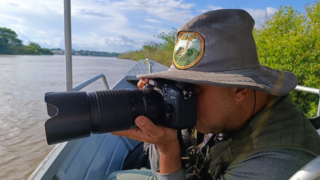 A man taking a picture of a body of water with a camera