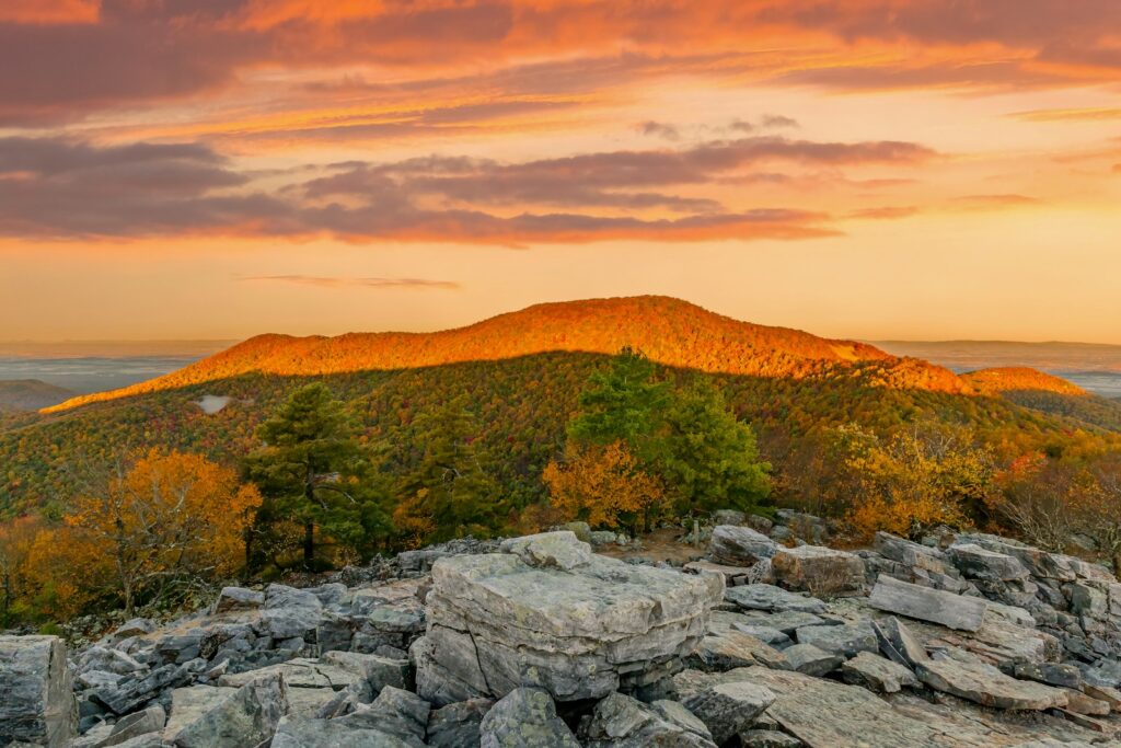 A view of a mountain with a sunset in the background